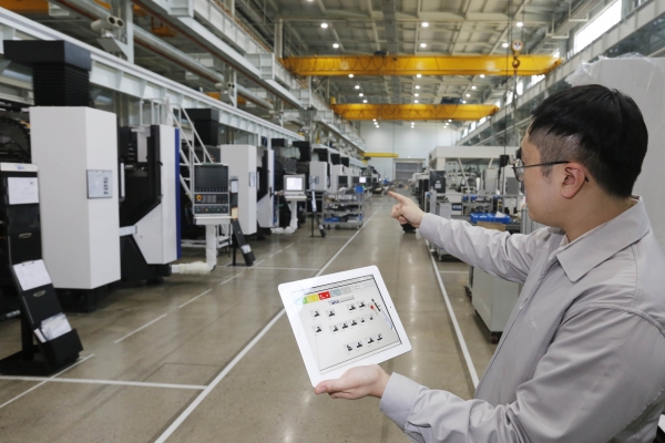 현대위아가 9일 러시아 예카테린부르크에서 열린 산업박람회 ‘이노프롬(INNOPROM)-2018’에서 발표한 스마트팩토리 IRIS의 모습. 현대위아의 한 직원이 IRIS를 이용해 공작기계를 실시간으로 살펴보고 있다. (사진=현대위아)