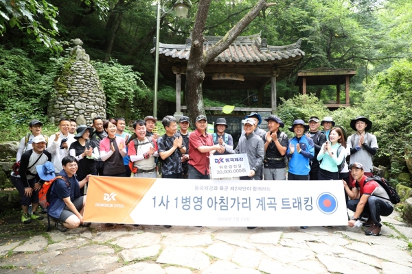 장세욱 동국제강 부회장(좌측)이 한영훈 2사단장(우측)에게 위문금을 전달하고 트래킹 기념 촬영을 하고 있다. (사진제공=동국제강)