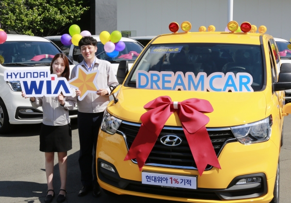 현대위아 임직원들이 1일 경남 창원시 성산구 현대위아 본사에서 열린 ‘2018년 DREAM CAR 전달식’에서 복지기관에 전달할 어린이 보호차량과 함께 기념사진을 찍고 있다. (사진=현대위아)