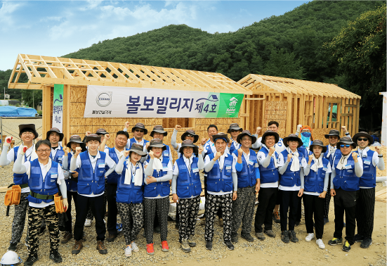 제4호 볼보 빌리지 건립 봉사활동에 참여한 임직원 및 가족들이 한데 모여 환하게 웃으며 기념 촬영을 하고 있다.  (사진=볼보건설기계코리아)