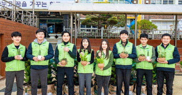 현대위아 직원들이 19일 ‘현대위아 초록학교’로 꼽힌 경상남도 창원시 남양초등학교에서 교실숲을 만들 화분을 들고 기념사진을 찍고 있다. (사진=현대위아)