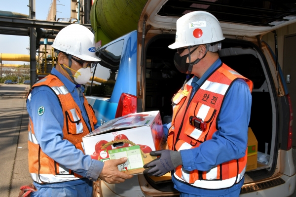 정송묵 포항제철소 제선부장(오른쪽)이 25일 자매마을인 해도동 대해종합시장에서 구입한 과일을 협력사 직원에게 전달하고 있다.
