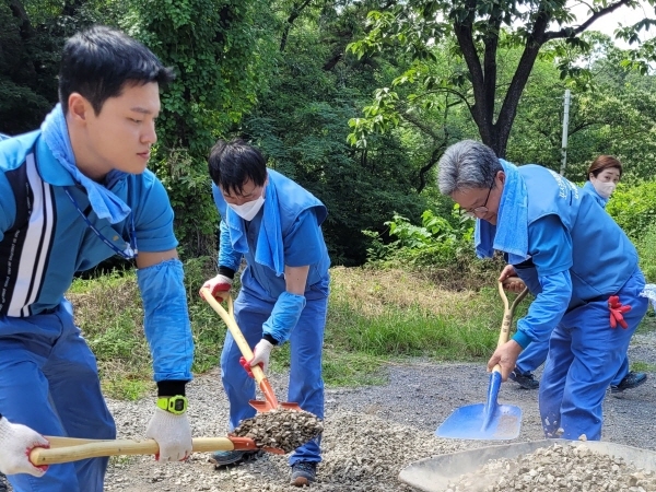 포스코스틸리온 윤양수 대표와 직원들이 운제산 산림욕장 진입 도로 보수 활동을 실시하고 있다. (사진=포스코스틸리온)