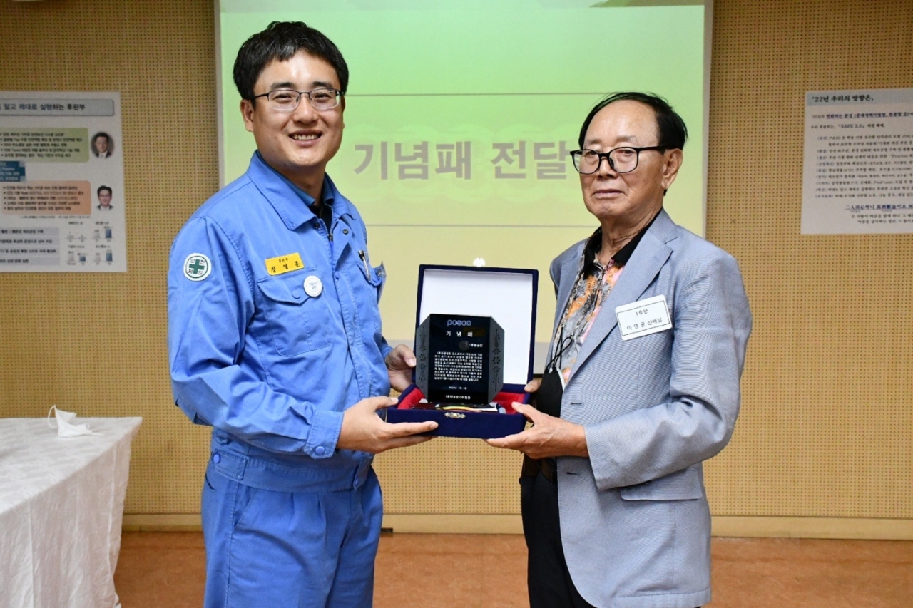 포항제철소 1후판공장 50주년 행사에서 후판공장에서 퇴직한 이영균씨가 1후판공장 장명훈 공장장에게 기념패를 전달하고 있다