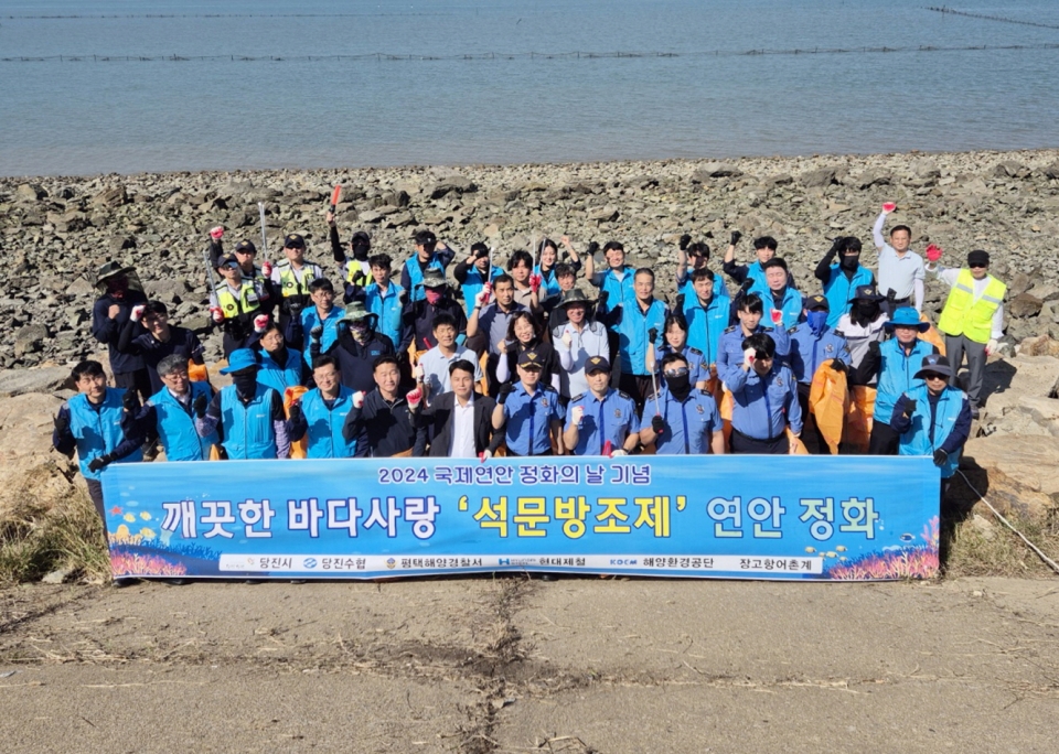 현대제철 당진제철소가 24일 석문방조제 일원에서 국제 연안정화의 날을 맞아 해양 정화 활동을 앞두고 기념 촬영을 하고 있다./ 현대제철